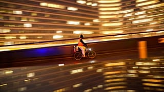 A cyclist, wearing a face mask to prevent the spread of the coronavirus COVID-19, rides a bicycle past the EU headquarters in Brussels