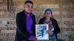 German y Maria Tomas posan para una fotografía sosteniendo un retrato enmarcado de su nieto Ivan Gudiel, en su casa en Comitancillo, Guatemala, el 27 de enero de 2021.