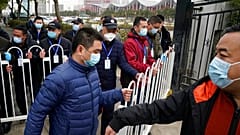 Security personnel move a barrier to clear the way for the World Health Organization team as they depart from the Wuhan Jinyintan Hospital after a field visit in Wuhan