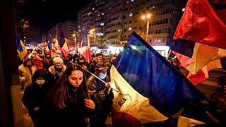 Protesters waving flags march after a deadly fire at a hospital treating COVID-19 patients in Bucharest, Romania, Saturday, Jan. 30, 2021. 