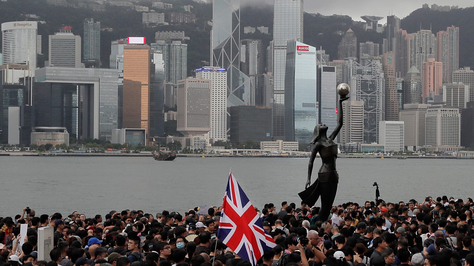FILE - In this July 7, 2019, file photo, thousands of protesters carrying the British flag march near the harbor of Hong Kong.