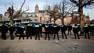 Police officers stand in line on the Museumplein in Amsterdam as Nederland in Verzet action group called for a protest against the Covid-19 guidelines