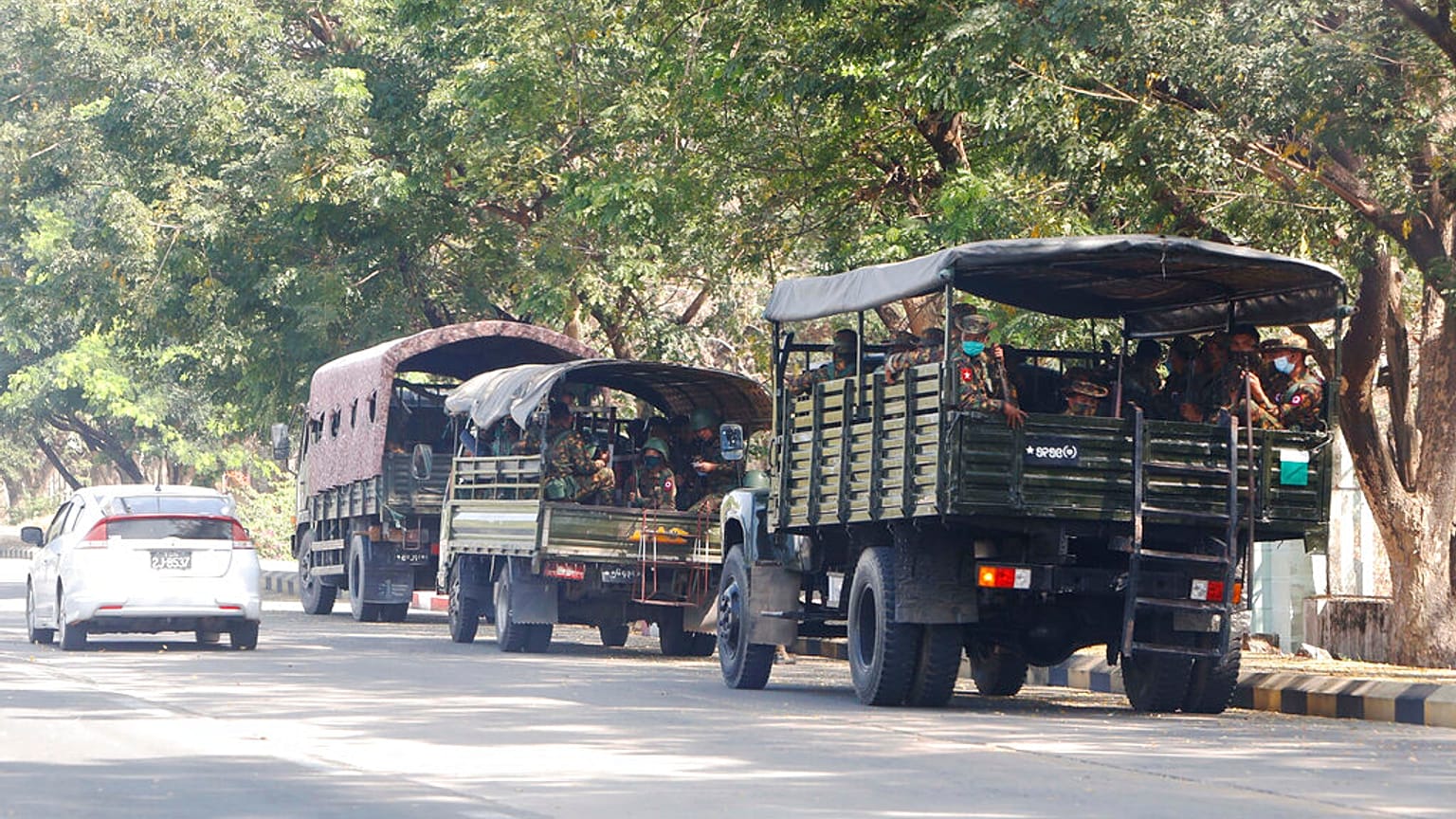 Soldiers sit inside trucks parked on a road in Naypyitaw, Myanmar, Monday, Feb. 1, 2021. 