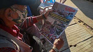Un hombre lee en un periódico el anuncio de los militares en la capital birmana