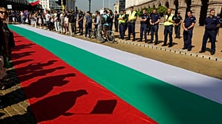 Protestors' shadows are cast on a giant Bulgarian flag amid demonstrations in Sofia demanding the government's resignation