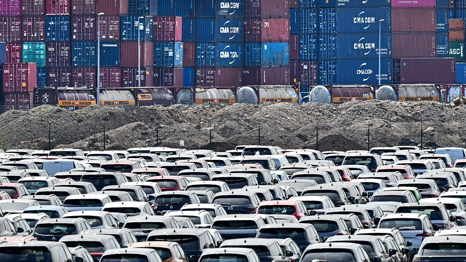 New cars are stored in front of containers at the 'logport' (logistic port) in Duisburg, Germany. Flle photo, Wednesday June 3, 2020.