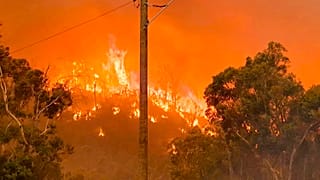 In this photo provided by Department of Fire and Emergency Services, fire burns on a hill at Wooroloo, near Perth, Australia