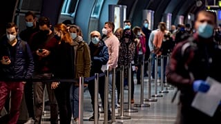 People queue at a Covid-19 test center at the airport in Frankfurt, Germany