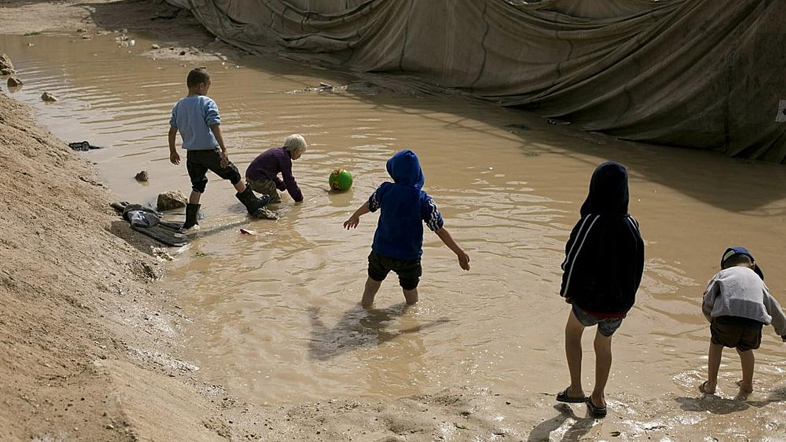 Kinder spielen in einer Pfütze im Lager Al-Hol in der Provinz Hasakeh, Syrien, im März 2019