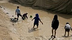 Kinder spielen in einer Pfütze im Lager Al-Hol in der Provinz Hasakeh, Syrien, im März 2019