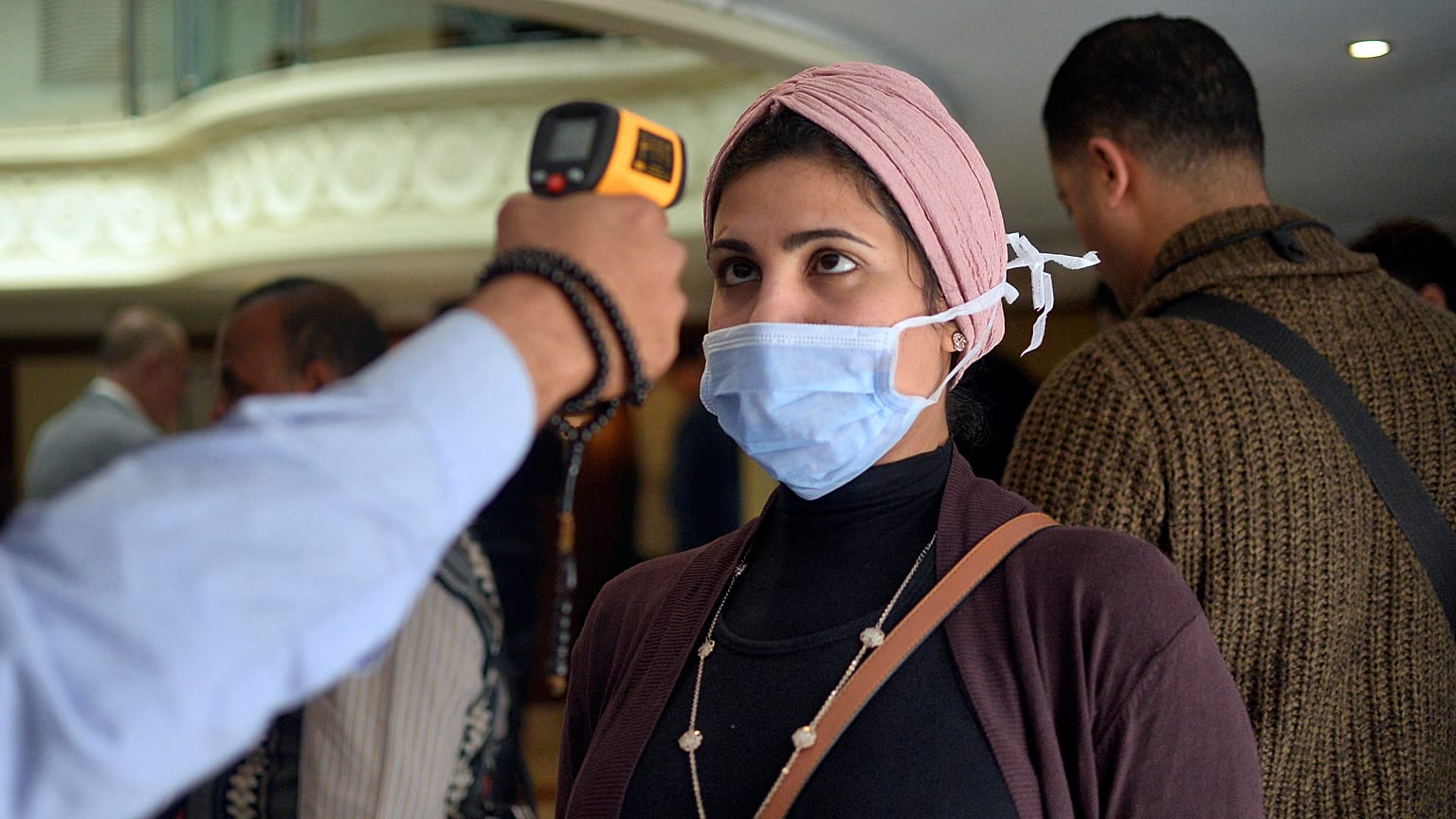 قياس درجة حرارة إمرأة مصرية في مدينة الإقصر وذلك في سياق الإجراءات التي اعتمدتها السلطات لمحاصرة جائحة كورونا.