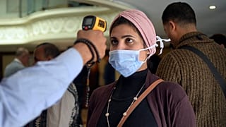 قياس درجة حرارة إمرأة مصرية في مدينة الإقصر وذلك في سياق الإجراءات التي اعتمدتها السلطات لمحاصرة جائحة كورونا.