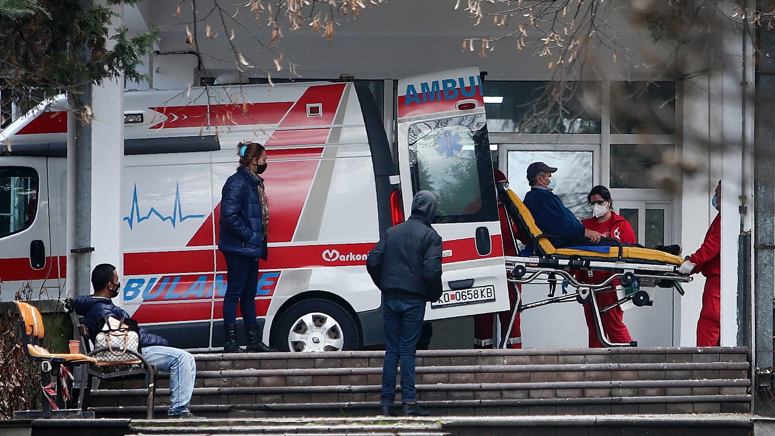 In this picture taken on Tuesday, Dec. 29, 2020, health workers wheel out a patient from an ambulance, at the entrance of the University Clinic complex in Skopje, North Macedo