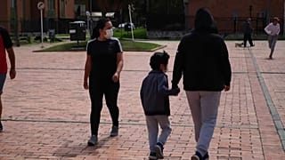 Una madre y su hijo caminan por la calle en Colombia