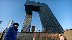 People walk past the CCTV Headquarters building, the home of Chinese state-run television network CCTV and its overseas arm CGTN, in Beijing on Feb. 4, 2021.