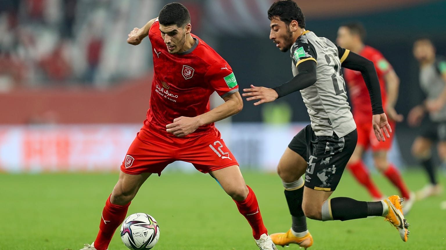 لاعب خط وسط نادي دحيل كريم بوضياف يراوغ لاعب وسط الأهلي أكرم توفيق خلال مباراة كرة القدم في الدور الثاني لكأس العالم للأندية في قطر