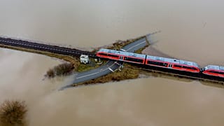 A train passes a railway crossing that is surrounded by flooding caused by rain and melting snow in Nidderau near Frankfurt, Germany. February 3, 2021