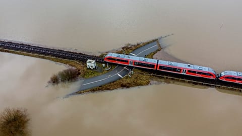 A train passes a railway crossing that is surrounded by flooding caused by rain and melting snow in Nidderau near Frankfurt, Germany. February 3, 2021