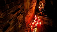 People light candles for the victims of a fire outside the Matei Bals hospital compound in Bucharest, Romania, Friday, Jan. 29, 2021.
