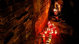 People light candles for the victims of a fire outside the Matei Bals hospital compound in Bucharest, Romania, Friday, Jan. 29, 2021.