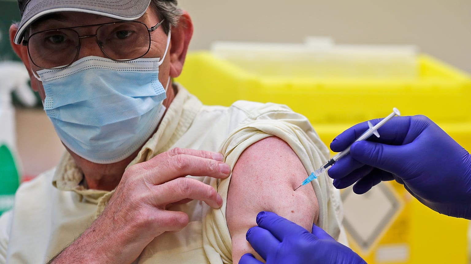 Doctor PJ Suresh injects a patient with the Pfizer/BioNtech COVID-19 vaccine at the Fullwell Cross Medical Centre in Ilford, London, Friday, Jan. 29, 2021. 