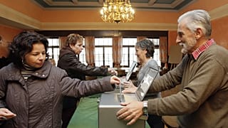 Women cast their ballots during the Federal Parliament elections 21 October 2007 at a polling station in Bulle, Switzerland. 
