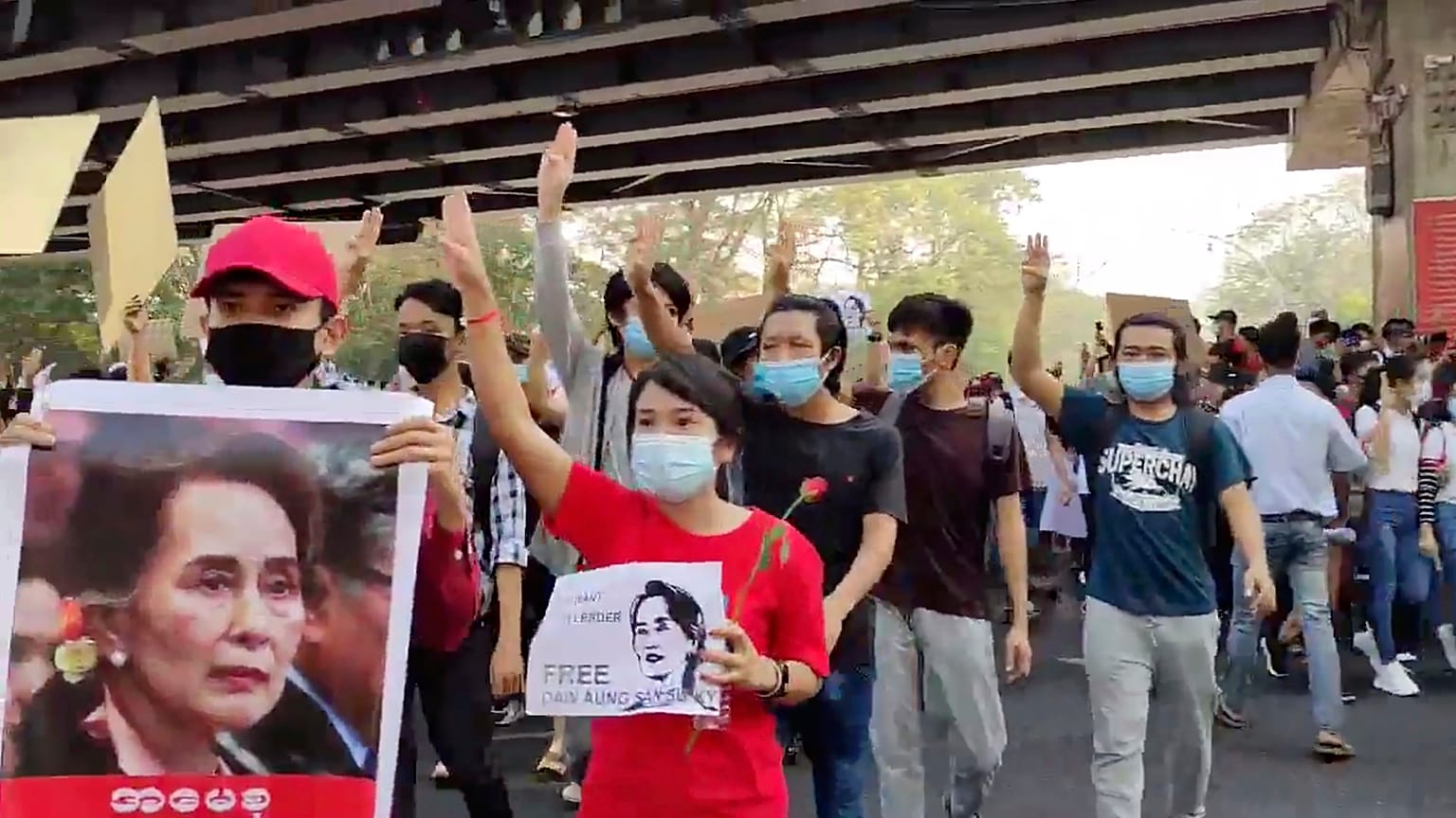 In this image provided by the Democratic Voice of Burma (DVB), protesters in Yangon hold images of deposed Myanmar leader Aung San Suu Kyi, Sunday, February 7, 2021.