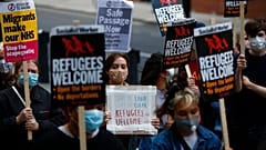 Protestors hold placards during a pro-migrants protest outside the government's Home Office in London, Tuesday, Aug. 25, 2020