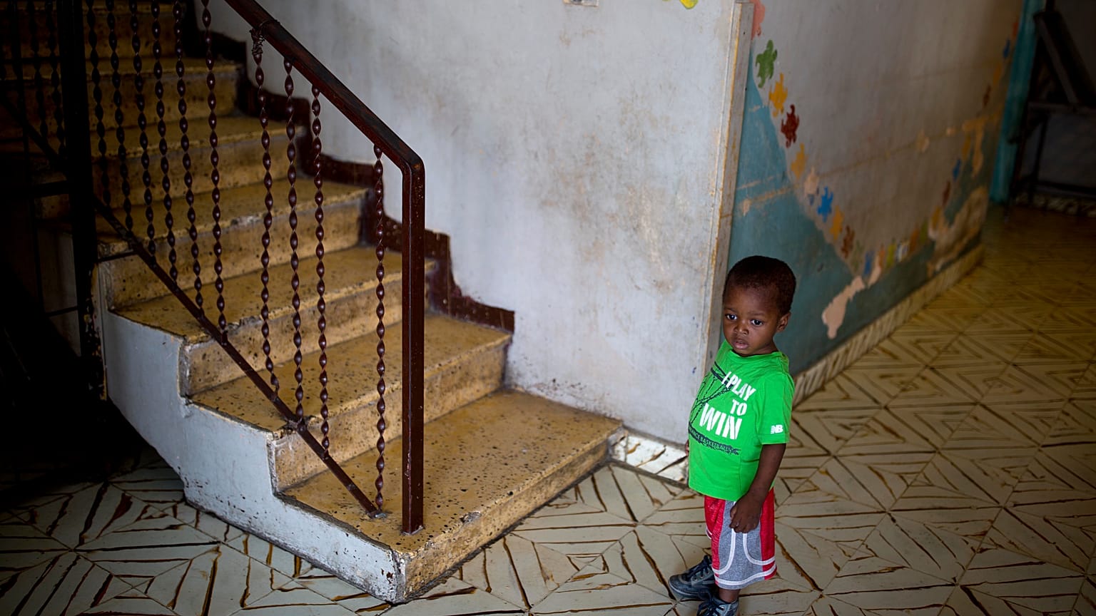 In this June 28, 2018 photo, a boy stands next to a staircase while looking out from the Nest of Hope orphanage in Port-au-Prince, Haiti. 