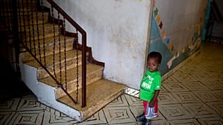 In this June 28, 2018 photo, a boy stands next to a staircase while looking out from the Nest of Hope orphanage in Port-au-Prince, Haiti.