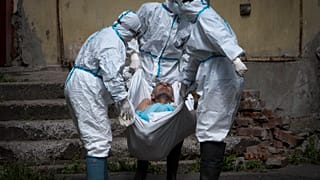 In this June 3, 2020 photo, medical workers carry a patient at infectious diseases hospital where patients with coronavirus are treated in St.Petersburg, Russia.