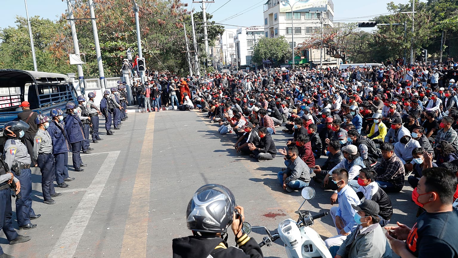 Protesters flash the three-fingered salute, a symbol of resistance, during a protest in Mandalay