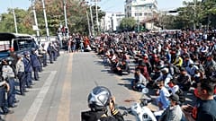 Protesters flash the three-fingered salute, a symbol of resistance, during a protest in Mandalay
