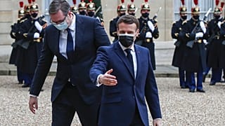 French President Emmanuel Macron, right, welcomes Serbian President Aleksandar Vucic for a working lunch at the Elysee Palace in Paris, Monday, Feb. 1, 2021.