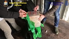 ضباط الشرطة الإيطالية يفتحون حقيبة مليئة بعبوات الكوكايين- أرشيف
