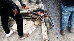 Des exilés se réchauffant au coin du feu dans un camp de fortune, à Calais, dans le nord de la France, le 31 janvier 2020.
