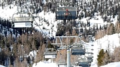 Un uomo seduto su una delle poche seggiovie aperte per gli allenamenti degli atleti, a Cortina D'Ampezzo 