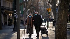Una pareja con mascarillas camina por un bulevar en Barcelona, España, el 27 de enero de 2021.