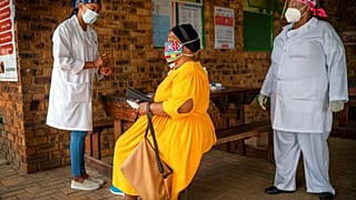 Uma mulher sul-africana ouve as explicações sobre o teste de despistagem de Covid-19 que se prepara para fazer