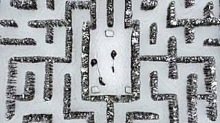 People walk with their dogs in a snow-covered garden maze in Gelsenkirchen, Germany. Extreme winter weather hit the north and west of the country. February 10, 2021