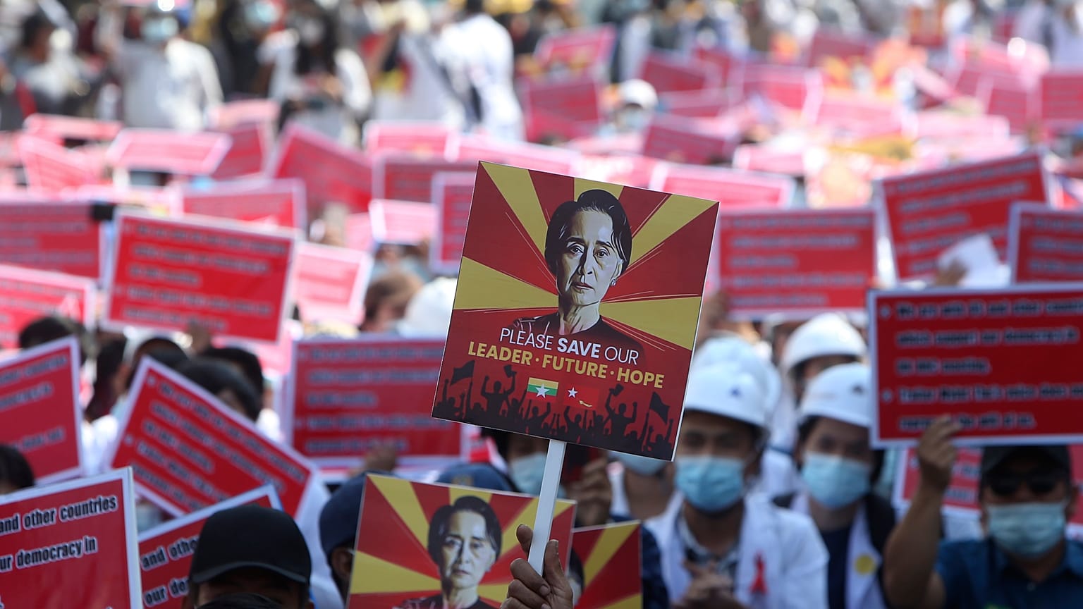 A protester holds up a placard with an image of deposed leader Aung San Suu Kyi during an anti-coup rally in front of the Mandalay railway station in Myanmar. Feb. 15, 2021.