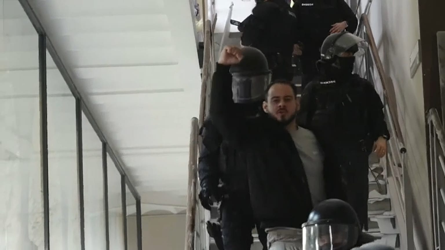 El rapero Pablo Hasel levanta el puño mientras la Policía le saca de la Universidad de Lleida