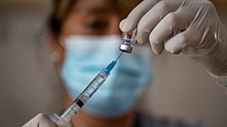 Una enfermera prepara una dosis de la vacuna cnotra la COVID-19
