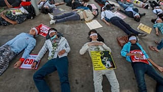 Demonstrators, with eyes blindfolded, lie down in the street to a protest a military coup in Yangon, Myanmar, Tuesday, Feb. 16, 2021. 