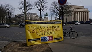 A banner reads « All united against political islamophobia » during a gathering in Paris, Sunday, Feb. 14, 2021.
