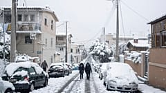People walk in a street of Petralona neighborhood of Athens
