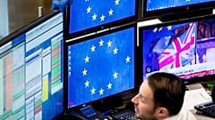 A computer screen shows news about the Brexit as a broker watches his screens at the stock market in Frankfurt, Germany, Wednesday, Jan. 16, 2019.