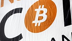 FILE: a bitcoin logo is displayed at the Inside Bitcoins conference and trade show, April 7, 2014 in New York.