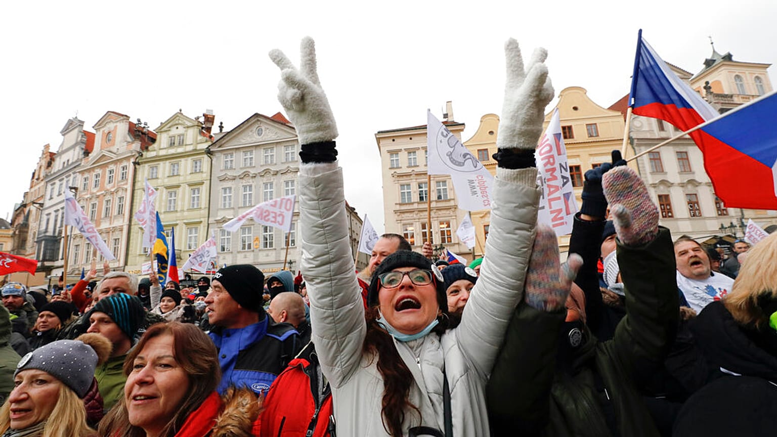 A woman flashes victory signs during a protest joined by thousands against the government restrictive measures to curb the spread of COVID-19 infections.