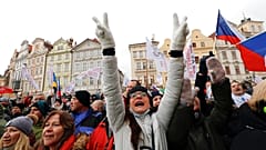 A woman flashes victory signs during a protest joined by thousands against the government restrictive measures to curb the spread of COVID-19 infections.